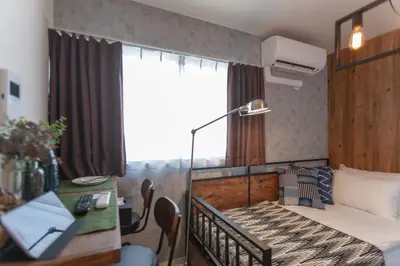 a bedroom with a bed and a desk and a window at Villettina\u6d45\u8349 in Tokyo