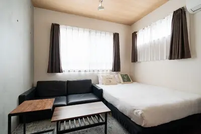 a small room with a bed and a couch at Villettina\u6d45\u8349 in Tokyo