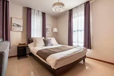 a bedroom with a bed and a large window at \u30b0\u30e9\u30ca\u30fc\u30c9\u516d\u672c\u6728 in Tokyo