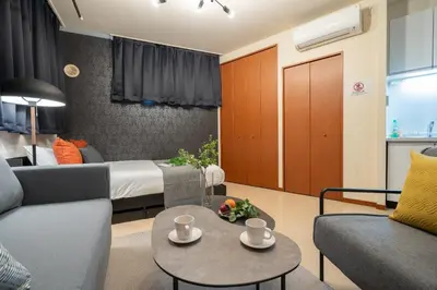 a living room with a bed and a couch and a table at \u30b0\u30e9\u30ca\u30fc\u30c9\u516d\u672c\u6728 in Tokyo