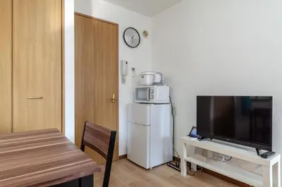 a kitchen with a refrigerator and a table with a television at \u30c8\u30eb\u30b3\u30d6\u30eb\u30fc\u30d3\u30eb in Tokyo