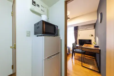 a small kitchen with a refrigerator and a table at \u30c8\u30eb\u30b3\u30d6\u30eb\u30fc\u30d3\u30eb in Tokyo