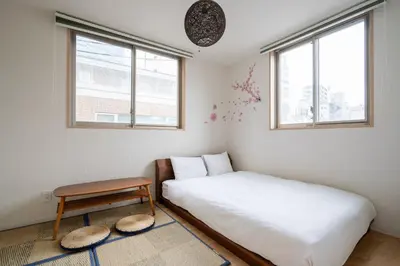 a small bedroom with a bed and a stool at City Oasis in Tokyo