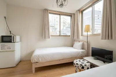 a small room with a bed and a tv at City Oasis in Tokyo