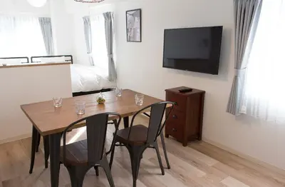 a dining room with a table and chairs and a television at \u30d5\u30ed\u30fc\u30ea\u30c3\u30b7\u30e521 in Tokyo