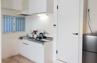 a white kitchen with a sink and a refrigerator at \u30d5\u30ed\u30fc\u30ea\u30c3\u30b7\u30e521 in Tokyo