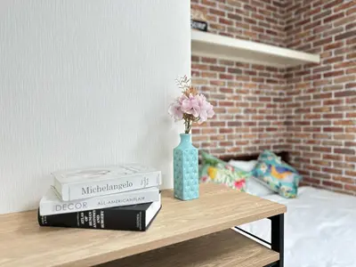 a table with books and a vase with flowers on it at nestay villa tokyo oyama in Tokyo