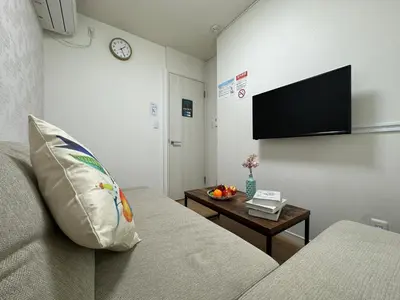 a living room with a couch and a table at nestay villa tokyo oyama in Tokyo
