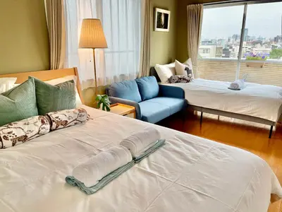 a hotel room with two beds and a blue chair at \u4e1c\u4eac\u65b0\u5bbf\u533a\u65e9\u7a3b\u7530\u5730\u94c1\u6b65\u884c5\u5206\u949fViewing House in Tokyo