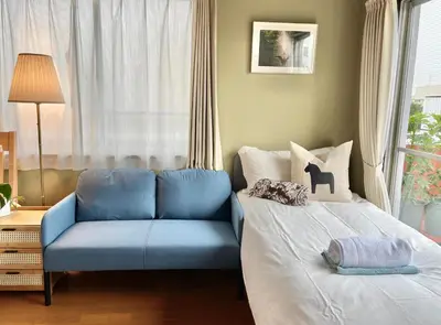 a bedroom with a bed and a blue couch at \u4e1c\u4eac\u65b0\u5bbf\u533a\u65e9\u7a3b\u7530\u5730\u94c1\u6b65\u884c5\u5206\u949fViewing House in Tokyo
