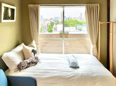 a bed in a room with a large window at \u4e1c\u4eac\u65b0\u5bbf\u533a\u65e9\u7a3b\u7530\u5730\u94c1\u6b65\u884c5\u5206\u949fViewing House in Tokyo