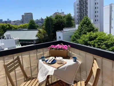 a table and chairs on a balcony with a view of a city at \u4e1c\u4eac\u65b0\u5bbf\u533a\u65e9\u7a3b\u7530\u5730\u94c1\u6b65\u884c5\u5206\u949fViewing House in Tokyo