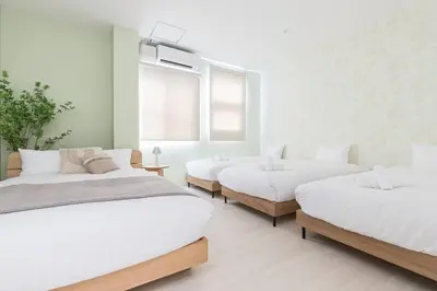 a white room with three beds and a window at Pufuka Hikifune \u3077\u3075\u304b\u66f3\u821f in Tokyo