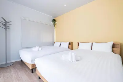 two beds with white sheets in a room at Pufuka Hikifune \u3077\u3075\u304b\u66f3\u821f in Tokyo