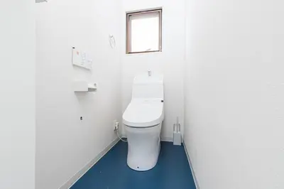a bathroom with a white toilet with a blue floor at Pufuka Hikifune \u3077\u3075\u304b\u66f3\u821f in Tokyo