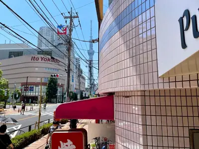 a building with a red suitcase next to a street at Pufuka Hikifune \u3077\u3075\u304b\u66f3\u821f in Tokyo