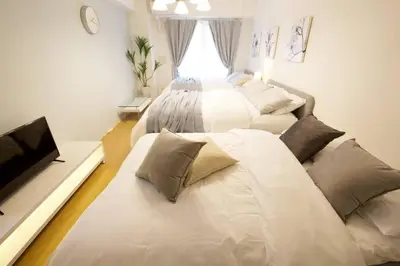 a bedroom with two beds and a flat screen tv at Generous Forest 201 in Tokyo
