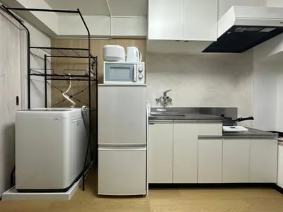a kitchen with a refrigerator and a microwave at nestay apartment tokyo otsuka in Tokyo