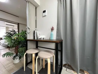 a table with two stools in a room at nestay apartment tokyo otsuka in Tokyo