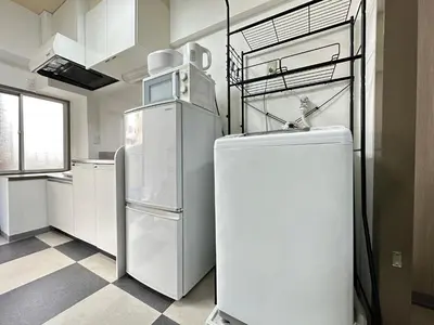 a kitchen with white appliances and a refrigerator at nestay apartment tokyo otsuka in Tokyo