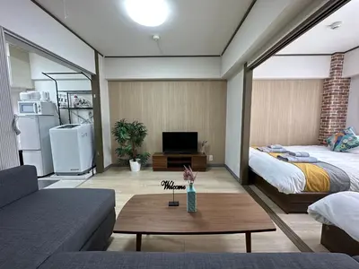 a living room with a bed and a couch at nestay apartment tokyo otsuka in Tokyo