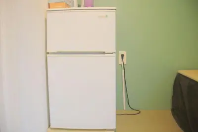 a white refrigerator in a room with a green wall at Hananogo Ikebukuro - Vacation STAY 16116v in Tokyo