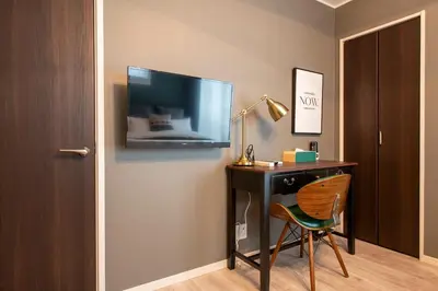 a room with a desk with a tv and a chair at Livion III in Tokyo