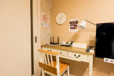 a room with a desk with a computer and a clock at Livion III in Tokyo