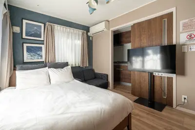 a bedroom with a bed and a flat screen tv at Livion III in Tokyo