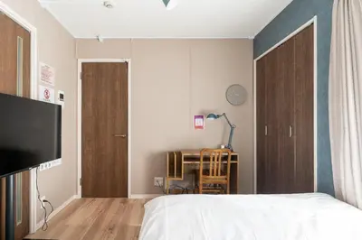 a bedroom with a bed and a table with a lamp at Livion III in Tokyo