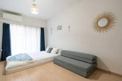 a bedroom with a bed and a chair and a mirror at KISETSU Omori I in Tokyo