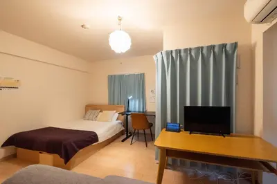 a bedroom with a bed and a desk with a television at KISETSU Omori I in Tokyo