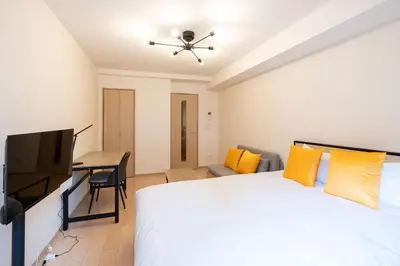 a bedroom with a bed and a tv and a desk at KISETSU Omori I in Tokyo