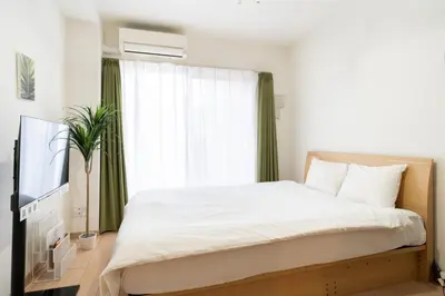a bedroom with a large bed and a window at KISETSU Omori I in Tokyo