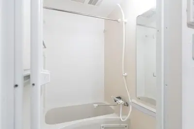a white bathroom with a shower and a sink at KISETSU Omori I in Tokyo