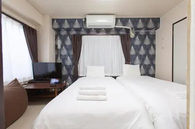 a bedroom with a white bed and a tv at YK building in Tokyo