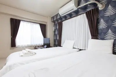 two beds in a hotel room with windows at YK building in Tokyo