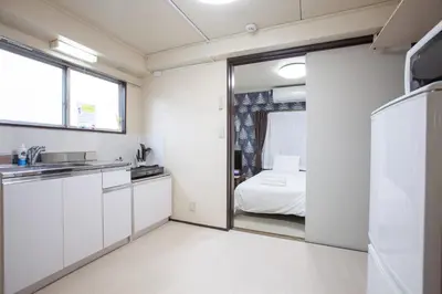 a kitchen with white cabinets and a bed in a room at YK building in Tokyo