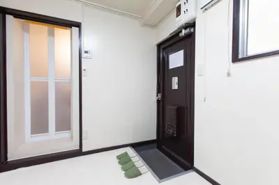 a room with a black door and green chairs at YK building in Tokyo