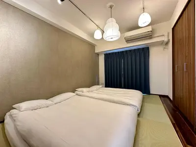 two beds in a small room with a window at 浅草寺3分 浅草駅6分 寝室+リビング2-4人 スカイツリービュー 駅近 成田空港&羽田空港直通 in Tokyo