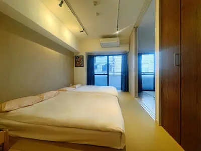 a bedroom with two beds in a room at 浅草寺3分 浅草駅6分 2寝室+リビング2-6人 スカイツリービュー 駅近 成田空港&羽田空港直通 in Tokyo