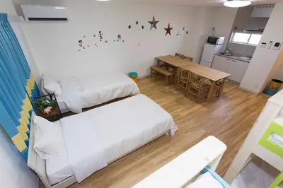 a room with two beds and a table and a kitchen at \u30d1\u30eb\u30c6\u30e9\u30b9\u5bcc\u58eb\u898b in Tokyo