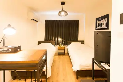 a bedroom with two beds and a desk and a table at \u30d1\u30eb\u30c6\u30e9\u30b9\u5bcc\u58eb\u898b in Tokyo