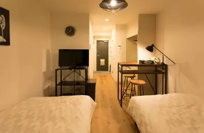 a room with two beds and a desk and a television at \u30d1\u30eb\u30c6\u30e9\u30b9\u5bcc\u58eb\u898b in Tokyo