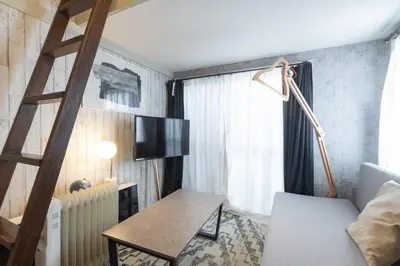 a living room with a television and a chair at \u8981\u753a\u30b7\u30c6\u30a3\u30cf\u30a4\u30e0 in Tokyo
