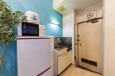 a kitchen with a white refrigerator and a microwave at \u8981\u753a\u30b7\u30c6\u30a3\u30cf\u30a4\u30e0 in Tokyo