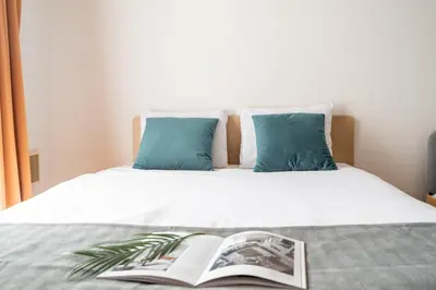 a bed with an open book on top of it at DeLCCS\u543e\u59bb\u6a4bIII in Tokyo
