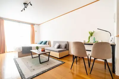 a living room with a couch and a table and chairs at DeLCCS\u543e\u59bb\u6a4bIII in Tokyo
