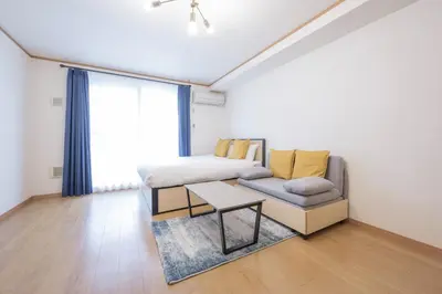 a bedroom with a bed and a couch and a table at DeLCCS\u543e\u59bb\u6a4bIII in Tokyo