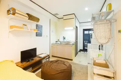 a living room with a couch and a kitchen at \u30b7\u30a7\u30e2\u30ef\u30ed\u30ef\u30a4\u30e4\u30eb in Tokyo